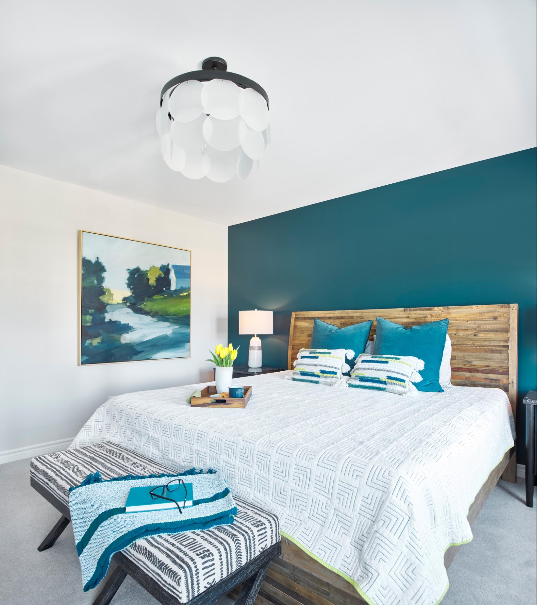 How Designers Help You Visualize Your Dream Space: A Modern Boho Retreat from Concept to Reality. Bedroom with blue accent wall and foot table.