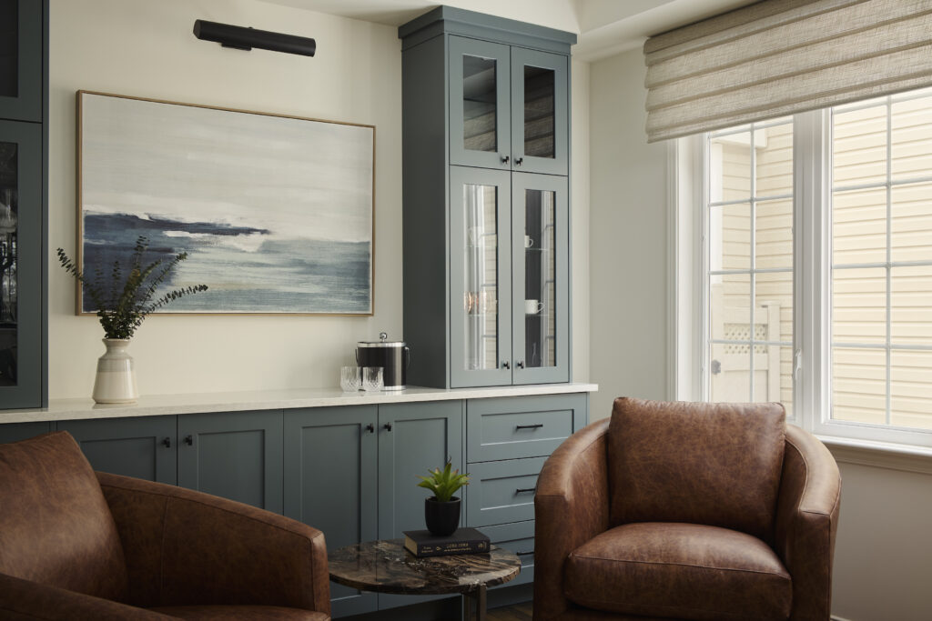 Stunning custom blue cabinetry stores glassware and surrounds a custom painting.